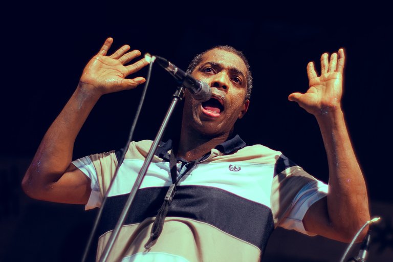 Femi Kuti at mic, hands in air